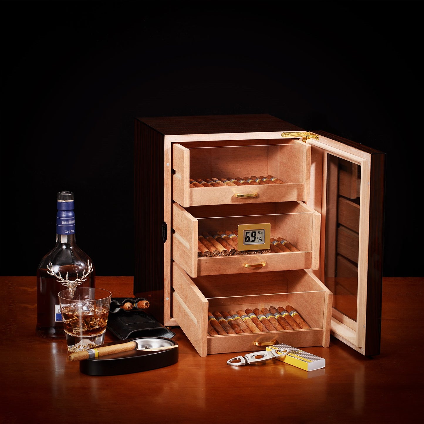 Humidor displayed with whiskey, ashtray, cutter, and cigars, perfect for luxury home bar decor.