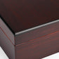 A detailed close-up of the exterior corner of the cigar humidor, showcasing the smooth, glossy dark reddish-brown wood grain and precise joinery.