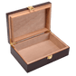An empty, open cigar humidor revealing its full light brown cedar wood interior, with gold-colored metal hinges and a front clasp visible.