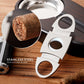 A close-up of a stainless steel guillotine cigar cutter, featuring a textured grip and sharp dual blades, with a magnified inset showing a cut cigar end, labeled "STAINLESS STEEL GUILLOTINE BLADE".