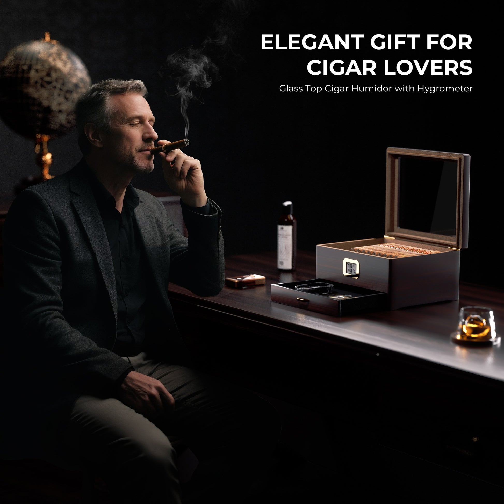 A sophisticated lifestyle scene featuring a distinguished man smoking a cigar, with a glass-top cigar humidor (with digital hygrometer), humidor solution, cigar cutter, and accessories arranged on a dark wooden desk, alongside a vintage globe and whiskey glass, with text overlay "ELEGANT GIFT FOR CIGAR LOVERS Glass Top Cigar Humidor with Hygrometer".