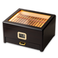 A dark wooden cigar humidor with a built-in LED-lit glass top, digital hygrometer, and pull-out accessory drawer, filled with premium cigars, set against a clean white background.