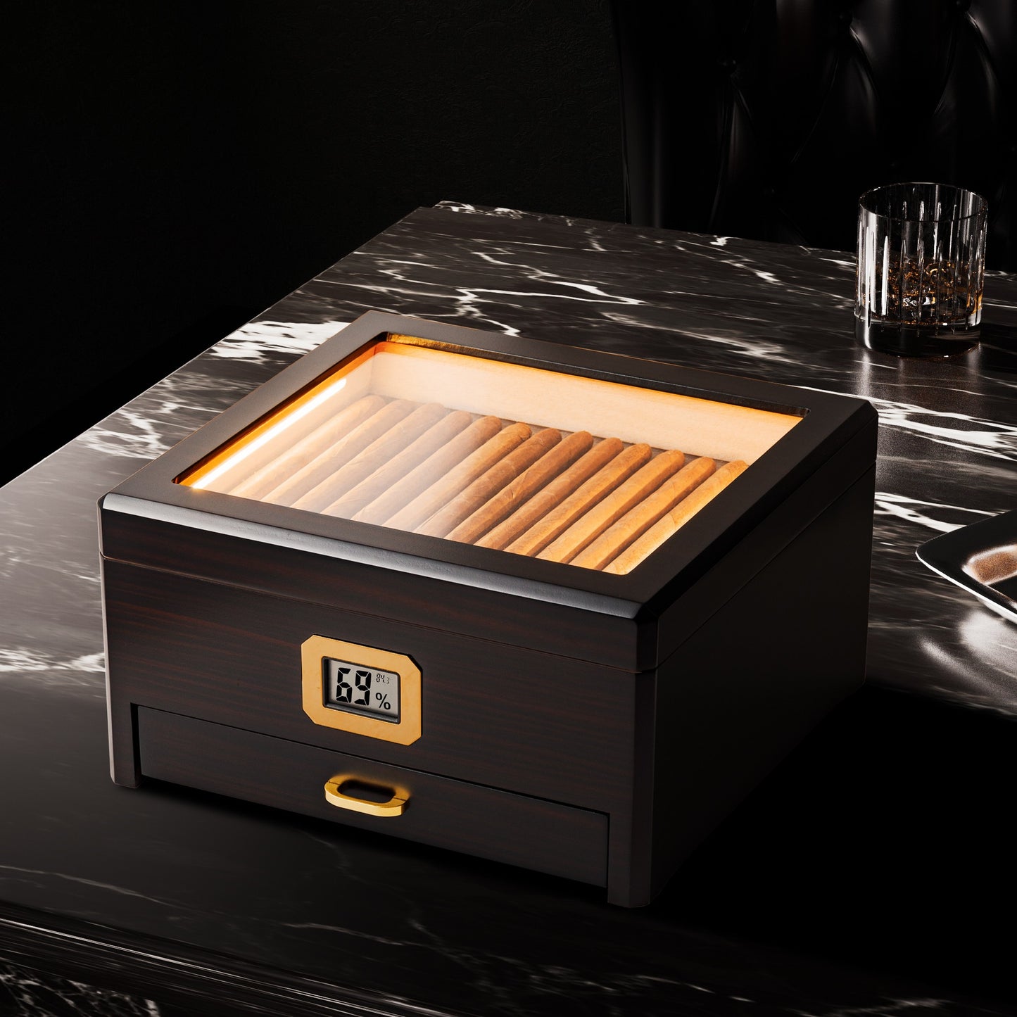 A sophisticated lifestyle shot of the LED-lit humidor placed on a black marble table, paired with a crystal whiskey glass and ashtray, creating an elegant premium aesthetic for cigar enthusiasts.