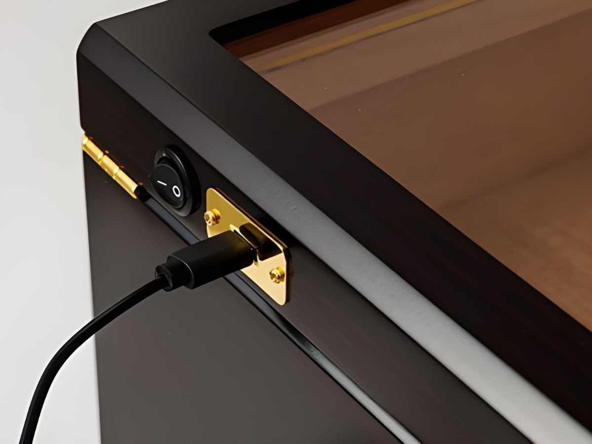 A close-up of the humidor’s side panel, showing the USB charging port and on/off switch for the built-in LED light, highlighting its convenient rechargeable design.