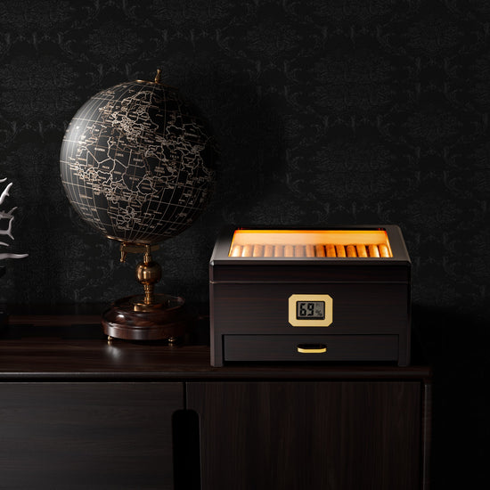 A refined study scene featuring the LED-lit humidor on a dark wooden cabinet, alongside a vintage globe, showcasing the humidor as a sophisticated decorative and functional piece.