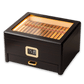 A dark wooden cigar humidor with a built-in LED-lit glass top, digital hygrometer, and pull-out accessory drawer, filled with premium cigars, set against a clean white background.