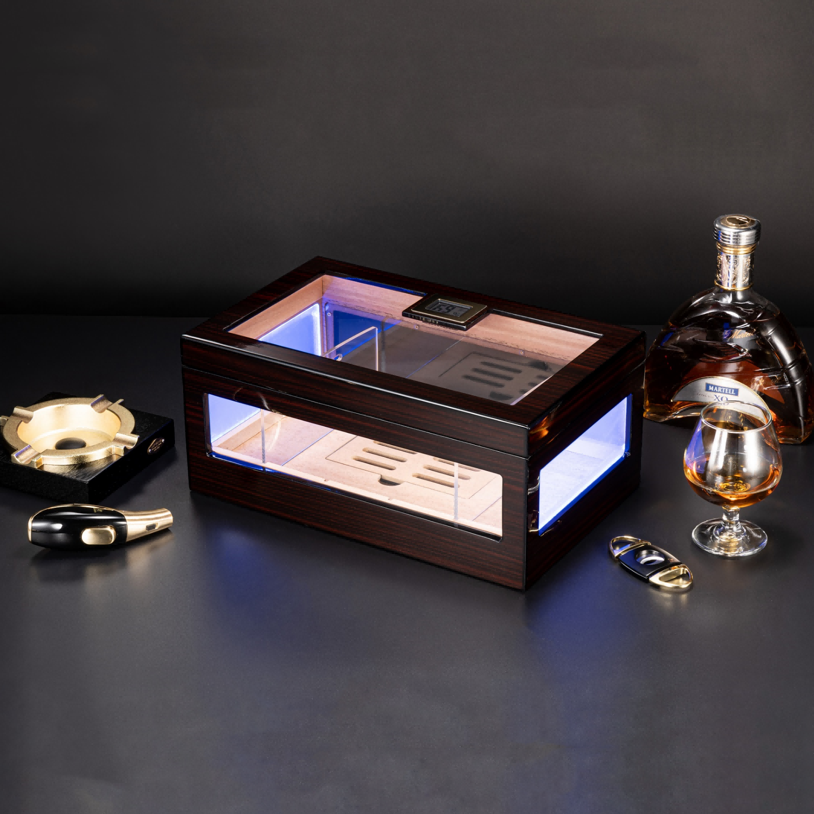 Ebony wood cigar humidor with RGB LED lighting, displayed with cigar ashtray, cutter, lighter, and whiskey, ideal for luxury home bar decor.