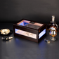 Ebony wood cigar humidor with RGB LED lighting, displayed with cigar ashtray, cutter, lighter, and whiskey, ideal for luxury home bar decor.