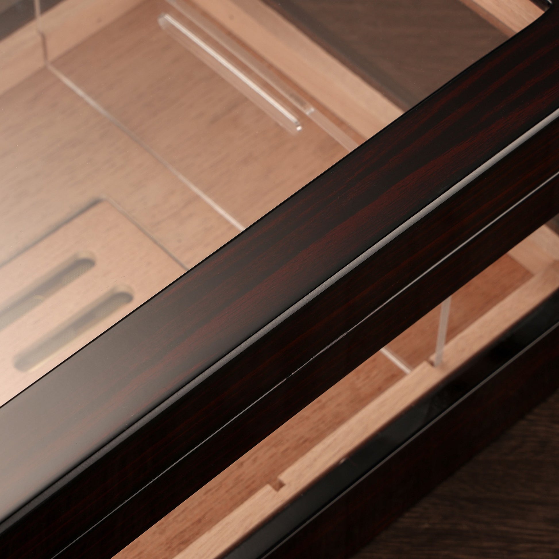 Close-up of high-gloss ebony wood finish on cigar humidor, highlighting premium craftsmanship and smooth, reflective surface.