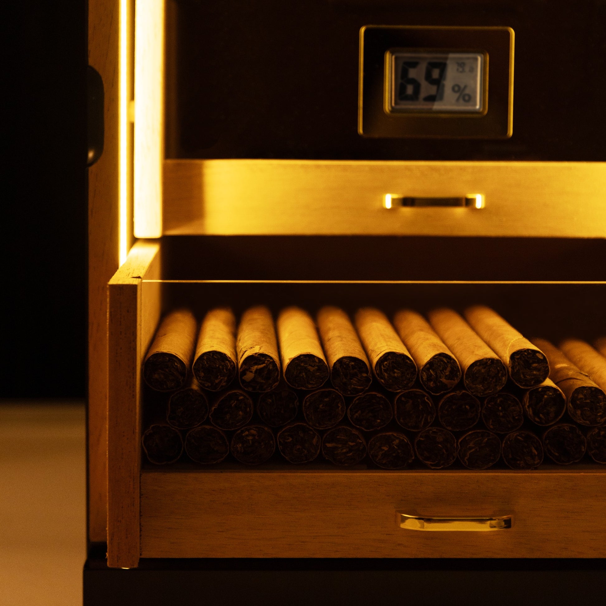 LED-lit cigar drawer showcasing neatly arranged cigars, highlighting warm illumination for premium display.