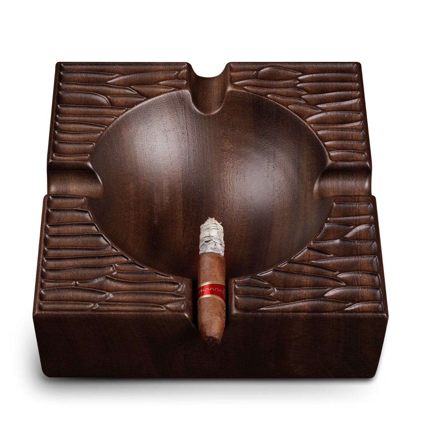 Close-up of square walnut ashtray holding a cigar, highlighting hand-carved details and functional rests.