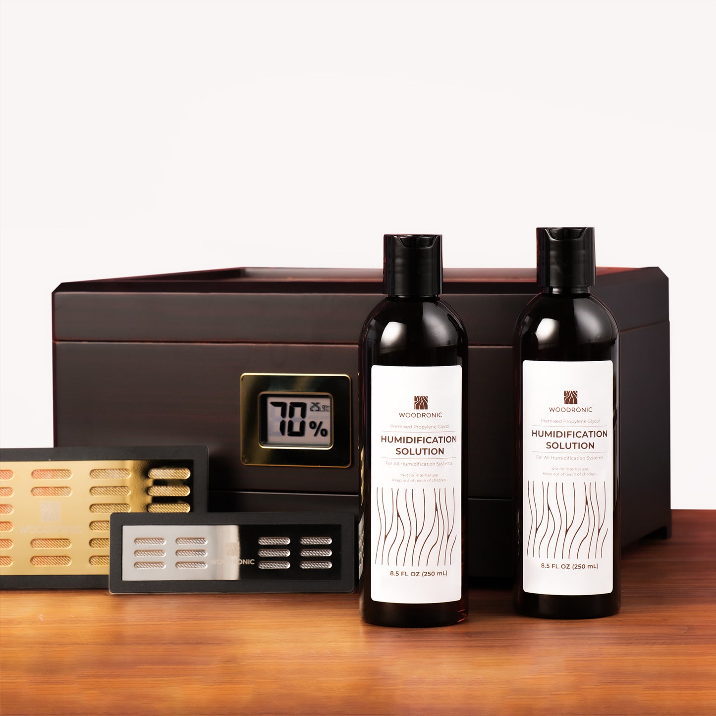 Two humidor solution bottles paired with crystal gel humidifiers and a humidor, showing complete cigar care setup.