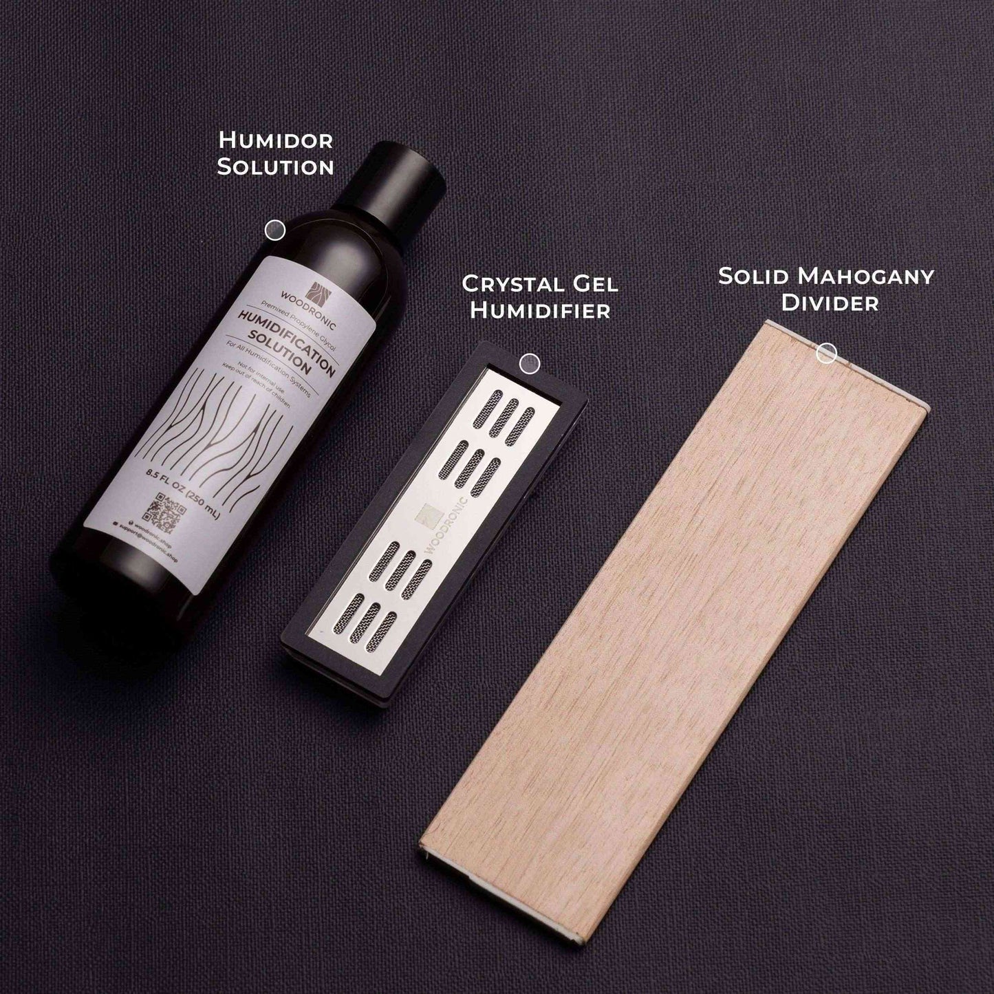 A labeled infographic of the humidor’s core humidification components: Humidor Solution, Crystal Gel Humidifier, and Solid Mahogany Divider, presented on a dark textured surface.