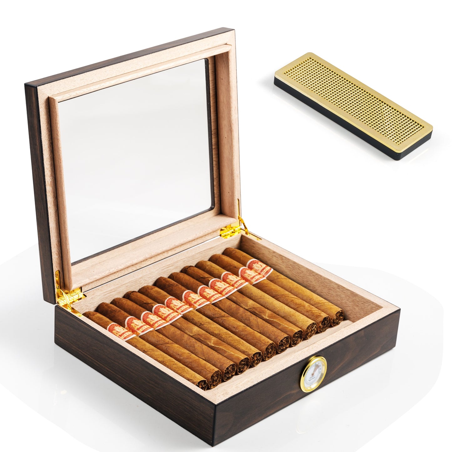 An open cigar humidor displaying its light cedar wood interior, filled with premium cigars, alongside a separate gold humidifier bar, with gold hinges visible on the lid.